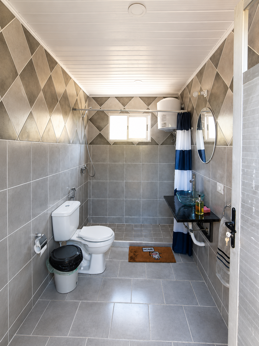 Baño con revestimiento gris y terminaciones sobrias y modernas
