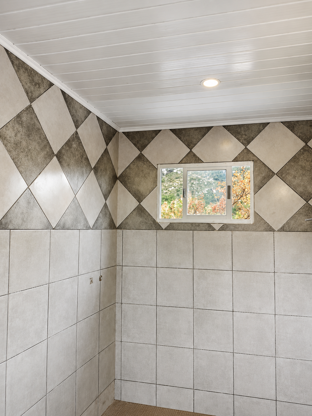 Baño revestido con azulejos geométricos y una propuesta visual muy definida