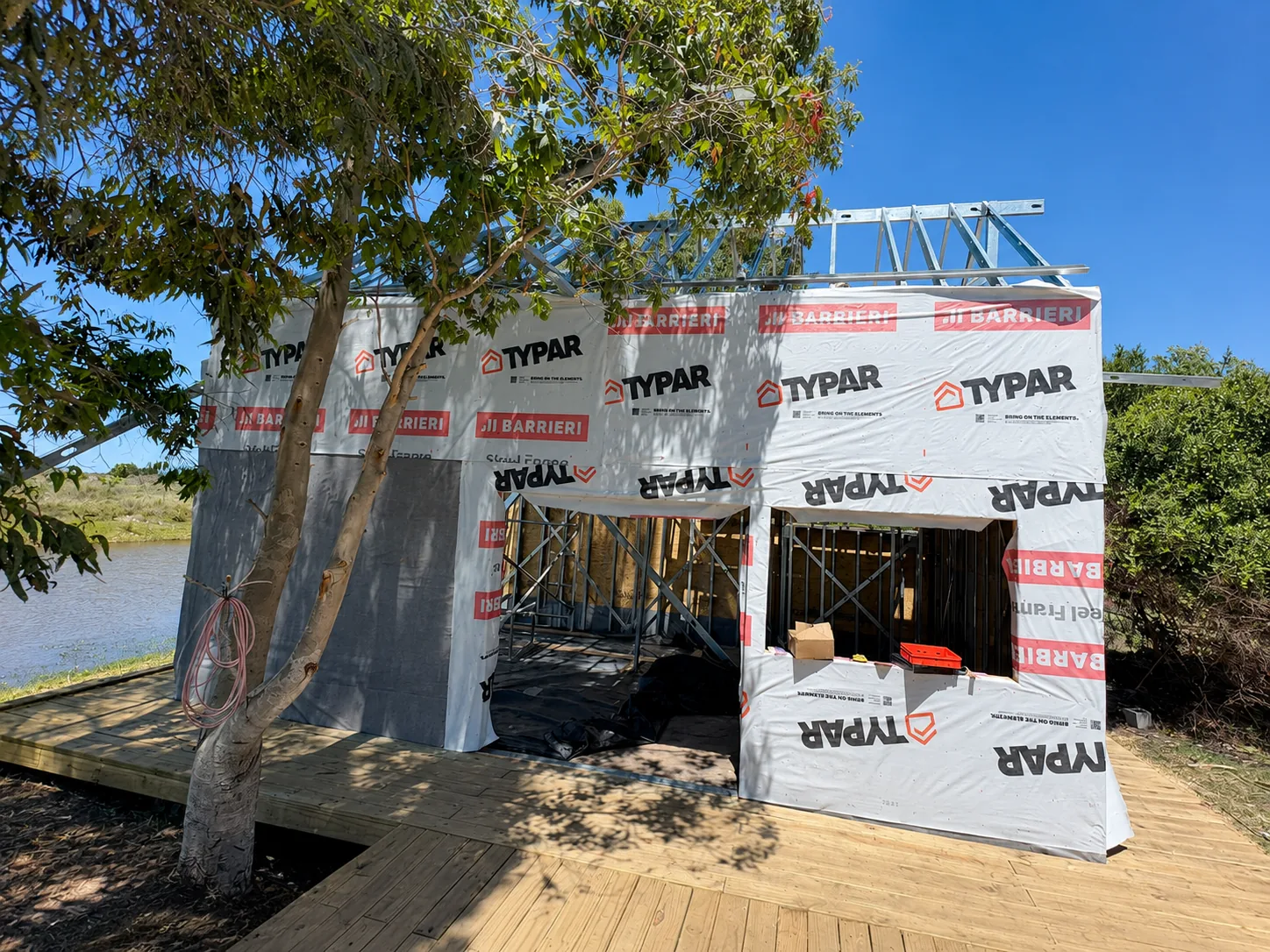 Cabaña en proceso con membrana exterior instalada junto al lago