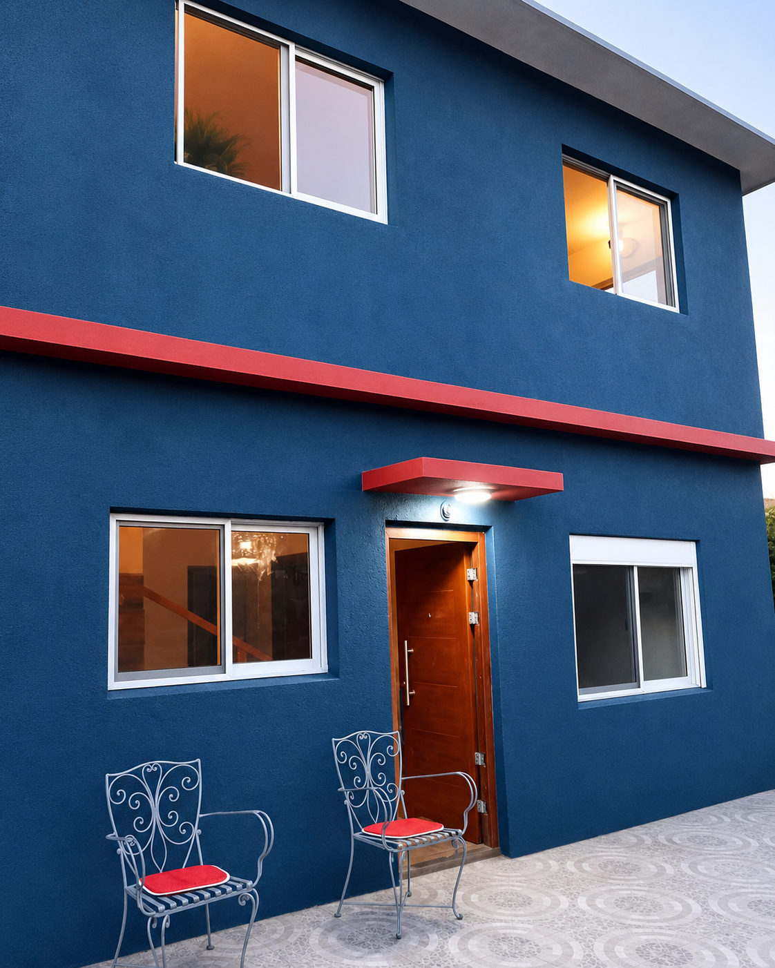 Fachada azul con detalles rojos que aportan carácter al volumen exterior
