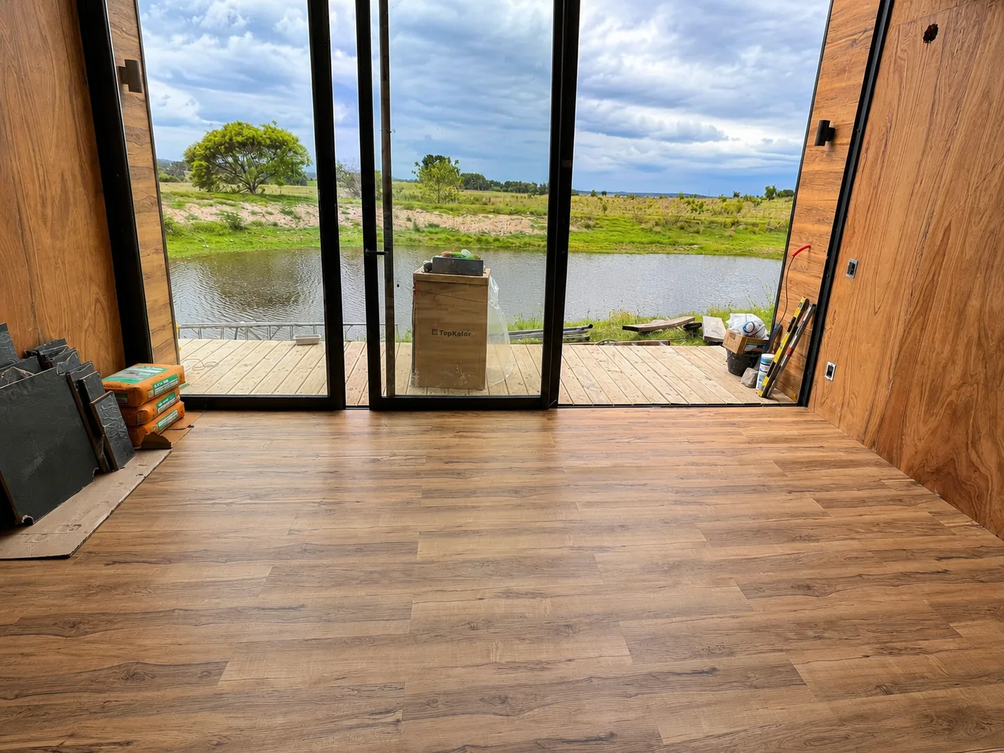 Interior de la cabaña con piso instalado y vista directa al lago