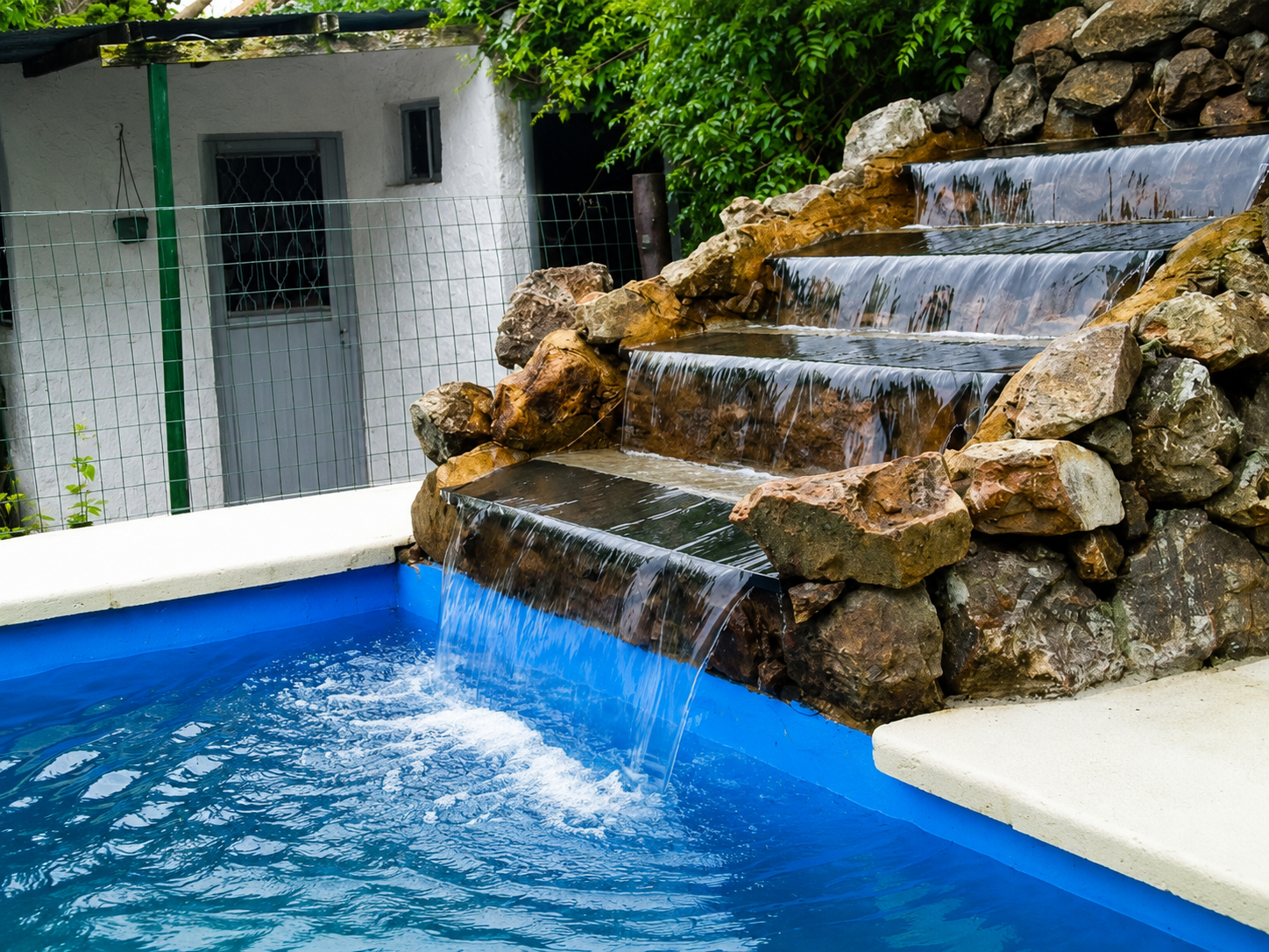 Piscina con cascada de piedra que destaca el diseño del área de recreación