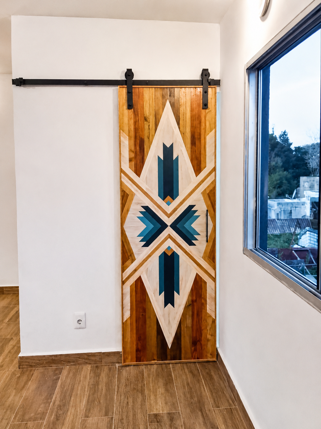 Puerta corrediza de madera con diseño geométrico y acabados muy cuidados